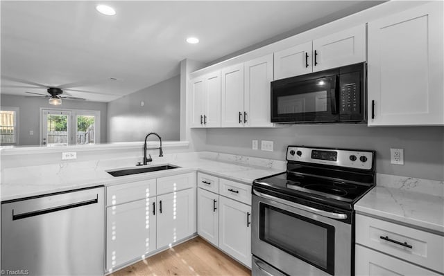 kitchen featuring a sink, a ceiling fan, stainless steel appliances, and white cabinetry