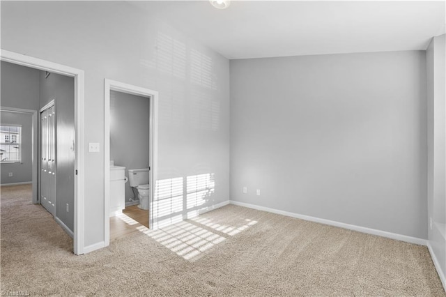 unfurnished bedroom featuring baseboards, carpet flooring, and ensuite bath