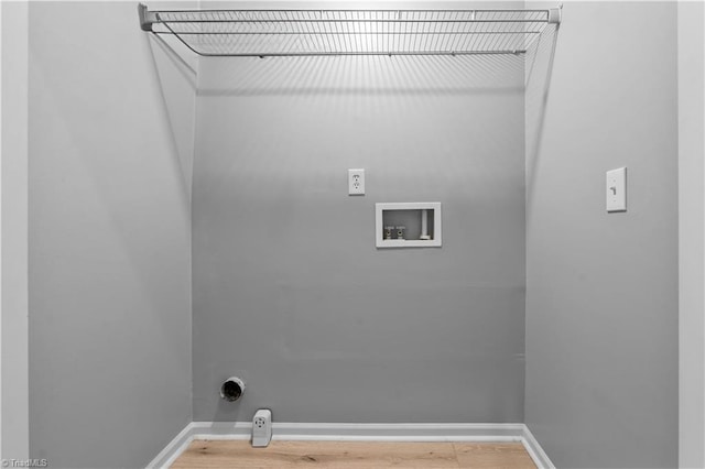 washroom with baseboards, hookup for a washing machine, wood finished floors, and hookup for an electric dryer
