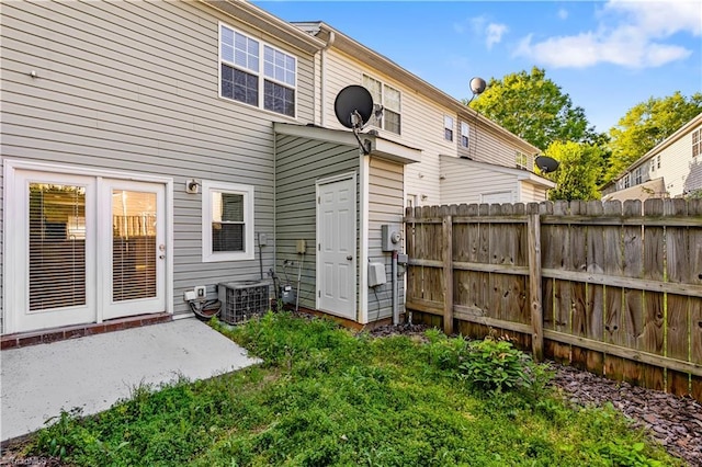 back of house with fence and central AC