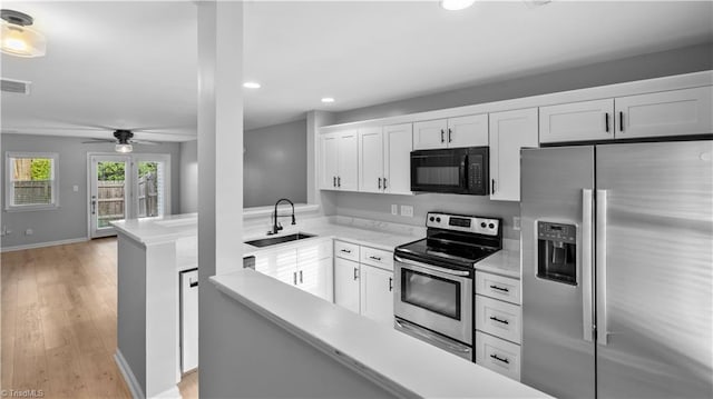 kitchen featuring a sink, light countertops, stainless steel appliances, and recessed lighting