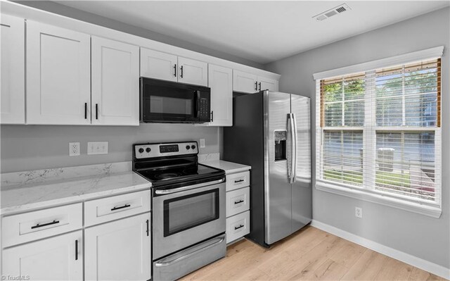 kitchen featuring appliances with stainless steel finishes, baseboards, white cabinets, light stone counters, and light wood finished floors