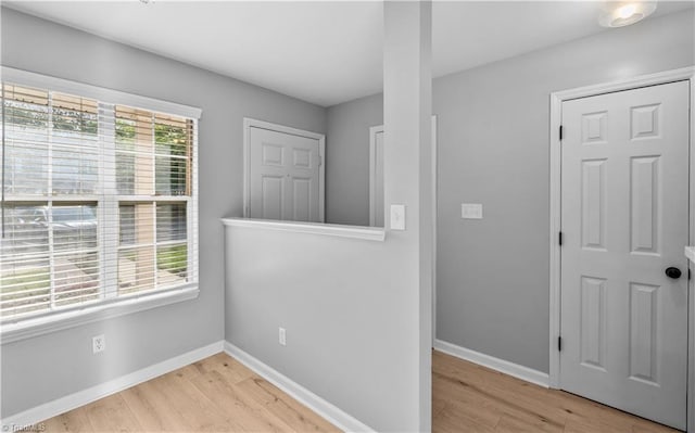 spare room with baseboards and light wood-style flooring