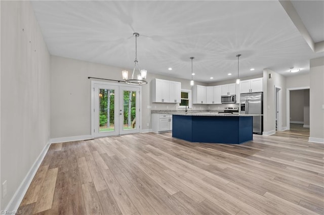 kitchen with stainless steel appliances, white cabinetry, a center island, light wood-style floors, and recessed lighting