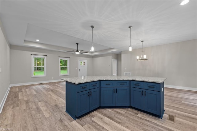 kitchen with a tray ceiling, light wood finished floors, baseboards, and recessed lighting