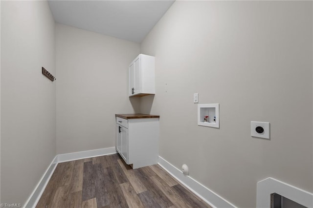 laundry area with electric dryer hookup, washer hookup, cabinet space, dark wood-type flooring, and baseboards