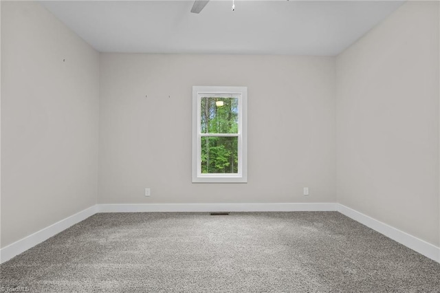 carpeted spare room with ceiling fan and baseboards