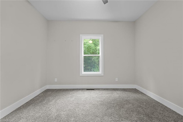 unfurnished room featuring carpet floors and baseboards
