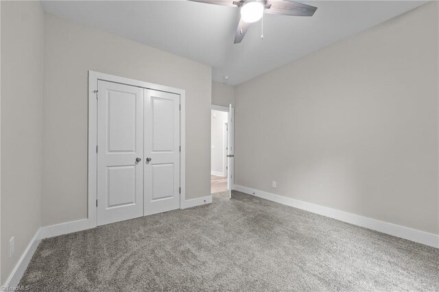unfurnished bedroom featuring carpet flooring, baseboards, a closet, and ceiling fan