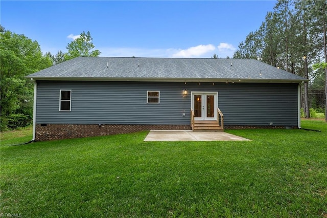 rear view of property with french doors, a patio, a yard, entry steps, and roof with shingles
