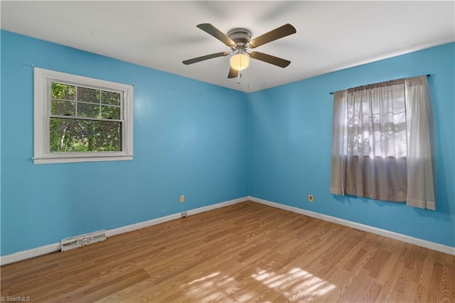 unfurnished room with baseboards, a ceiling fan, wood finished floors, and visible vents