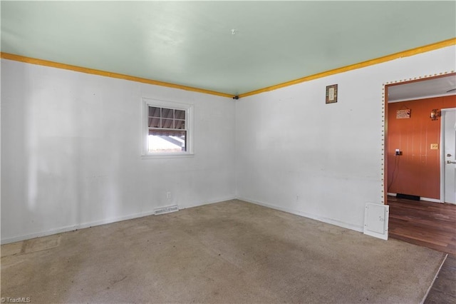 empty room featuring baseboards, ornamental molding, and visible vents