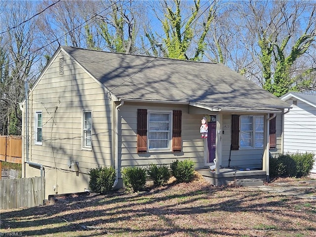 view of front of property with fence and a shingled roof