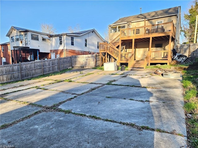 back of property featuring stairs, a deck, and fence