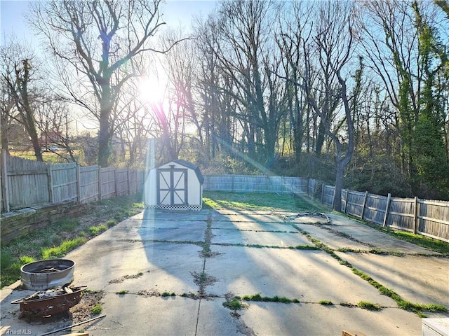 view of swimming pool featuring an outbuilding, a shed, a patio, and a fenced backyard