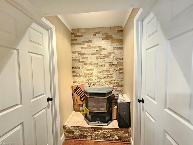 interior space with crown molding and a wood stove