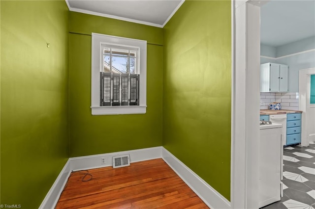 spare room with crown molding and light wood-type flooring