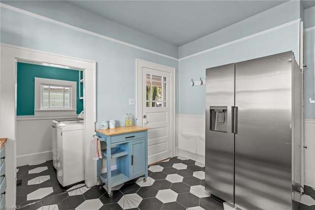 kitchen featuring a wealth of natural light, wooden counters, washer / clothes dryer, and stainless steel fridge