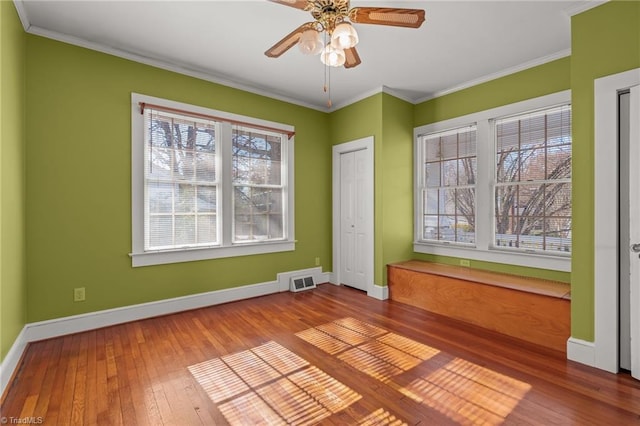 empty room with hardwood / wood-style flooring, ceiling fan, and crown molding