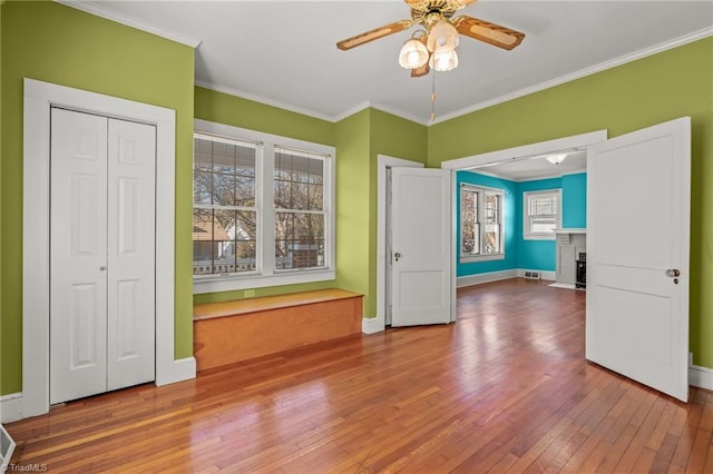 spare room featuring plenty of natural light, hardwood / wood-style floors, and crown molding