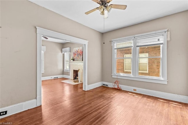 524 Horah St, Salisbury, NC 28144 - unfurnished living room with wood finished floors, ceiling fan, a fireplace, and a wall unit AC