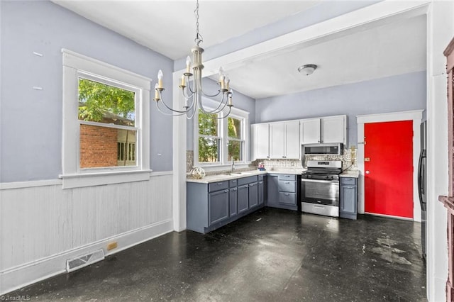 524 Horah St, Salisbury, NC 28144 - kitchen featuring stainless steel appliances, gray cabinets, wainscoting, plenty of natural light, and a chandelier