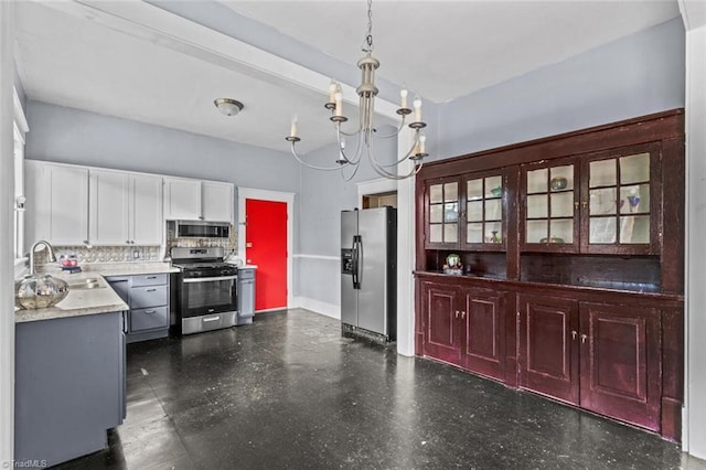 524 Horah St, Salisbury, NC 28144 - kitchen with appliances with stainless steel finishes, a chandelier, dark floors, decorative backsplash, and decorative light fixtures