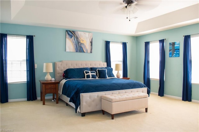 3029 Zacharys Keep Ct, Winston-Salem, NC 27103 - bedroom with a tray ceiling, light carpet, multiple windows, and ceiling fan