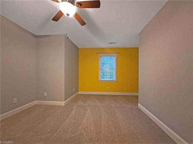 spare room with ceiling fan, carpet, and a textured ceiling