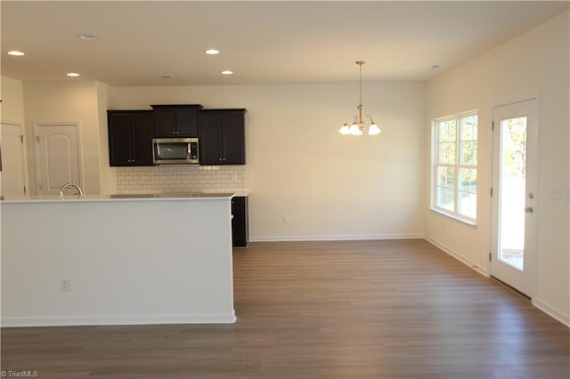 kitchen with tasteful backsplash, wood-type flooring, and a healthy amount of sunlight