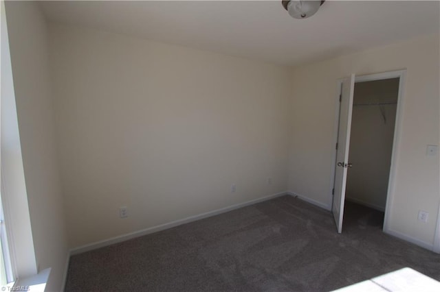 unfurnished room with dark carpet