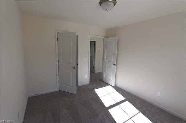 unfurnished bedroom with dark carpet