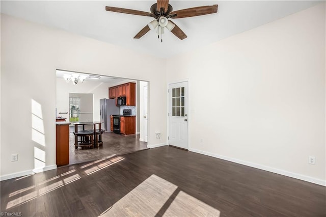 spare room featuring ceiling fan with notable chandelier and dark wood-type flooring