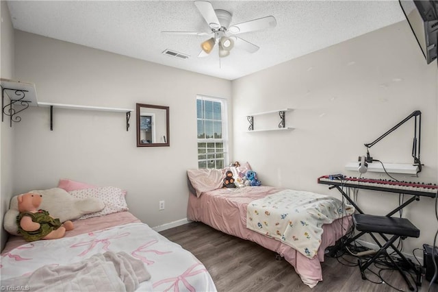 bedroom with a textured ceiling, dark hardwood / wood-style flooring, and ceiling fan