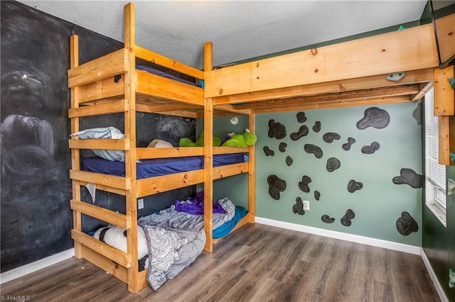 bedroom featuring a textured ceiling and dark hardwood / wood-style floors