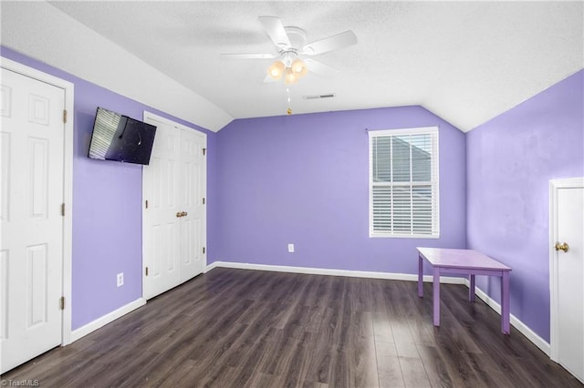 unfurnished bedroom with a textured ceiling, dark hardwood / wood-style flooring, ceiling fan, and lofted ceiling