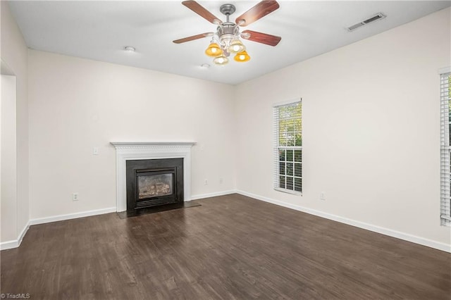 unfurnished living room with dark hardwood / wood-style flooring and ceiling fan