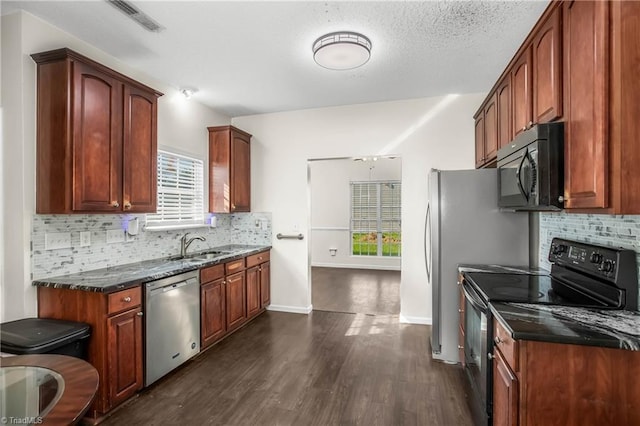 kitchen with dark hardwood / wood-style flooring, backsplash, a textured ceiling, black appliances, and dark stone countertops