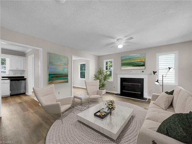 living room with plenty of natural light, a textured ceiling, ceiling fan, and hardwood / wood-style floors