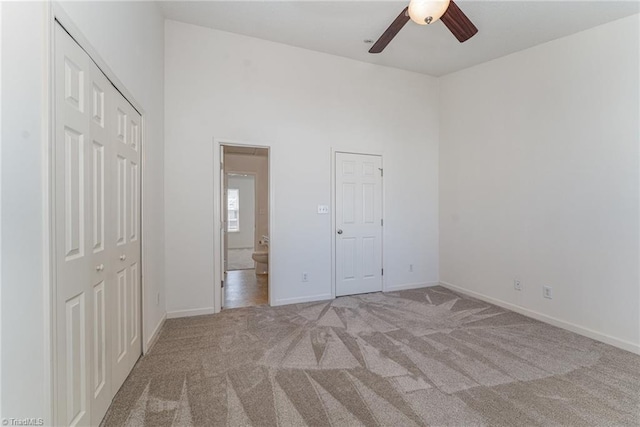 unfurnished bedroom featuring baseboards, a high ceiling, and carpet flooring