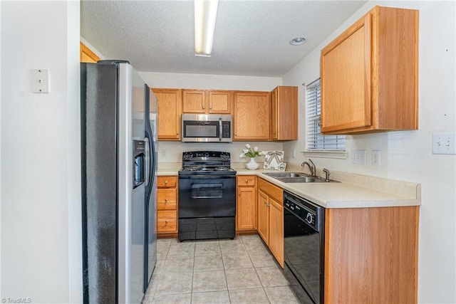 kitchen featuring light tile patterned floors, black appliances, light countertops, and a sink