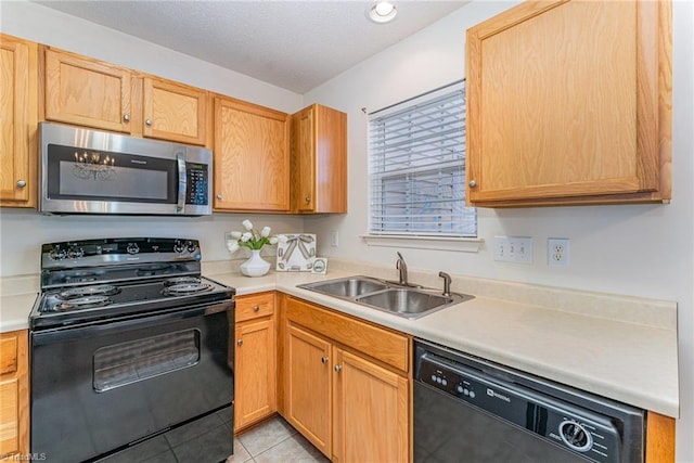 kitchen featuring black appliances, a sink, a textured ceiling, light countertops, and light tile patterned floors