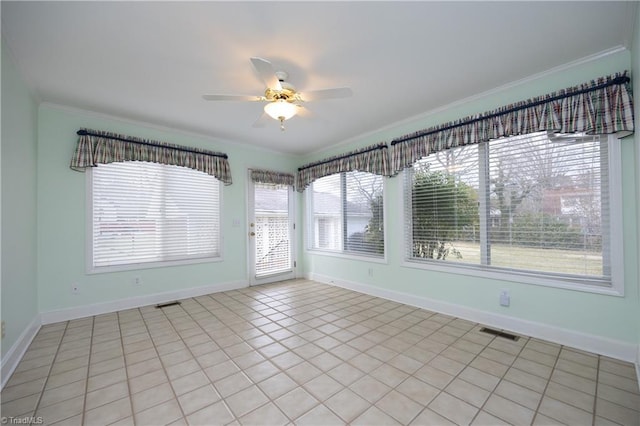 spare room featuring light tile patterned floors, ornamental molding, and ceiling fan