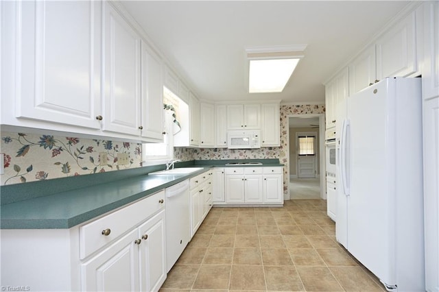 kitchen featuring sink, white appliances, and white cabinets