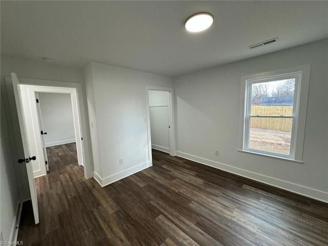 unfurnished bedroom featuring a closet and dark wood-type flooring