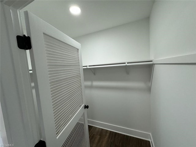 walk in closet with dark wood-type flooring