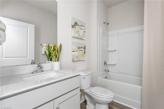 full bathroom featuring bathing tub / shower combination, hardwood / wood-style floors, vanity, and toilet