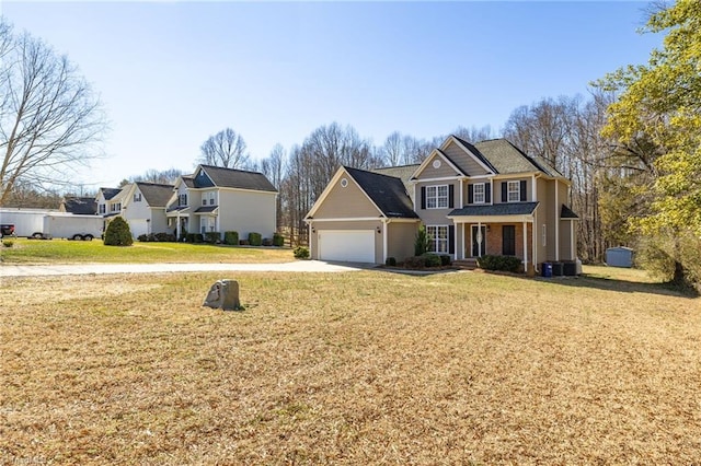 view of front of property with an attached garage, covered porch, central AC, driveway, and a front lawn