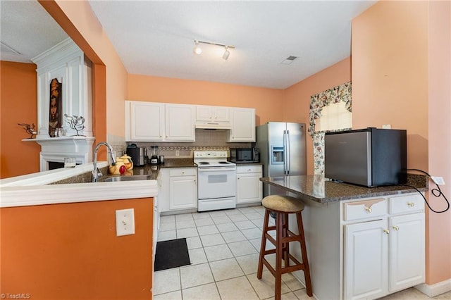 3902 Elizabeth Glen Way, Jamestown, NC 27282 - kitchen featuring white electric range, a peninsula, black microwave, and freestanding refrigerator