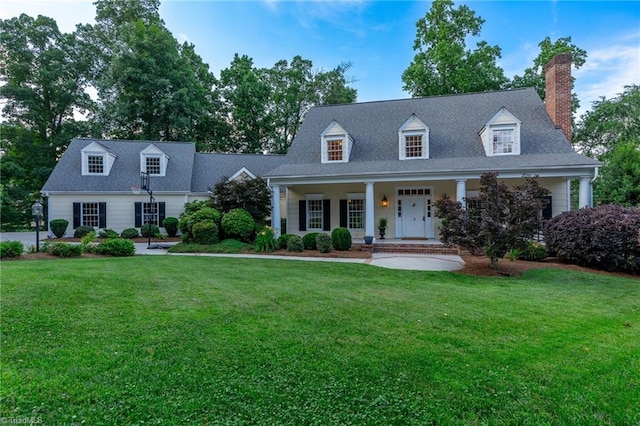 cape cod home featuring a front yard and covered porch